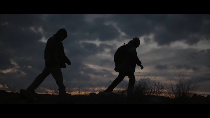 Imagen de los dos criminales caminado por el campo bajo el crepúsculo del anochecer